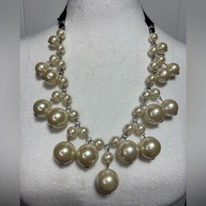 Small  and large faux pearls on silver tone necklace with black ribbon tie